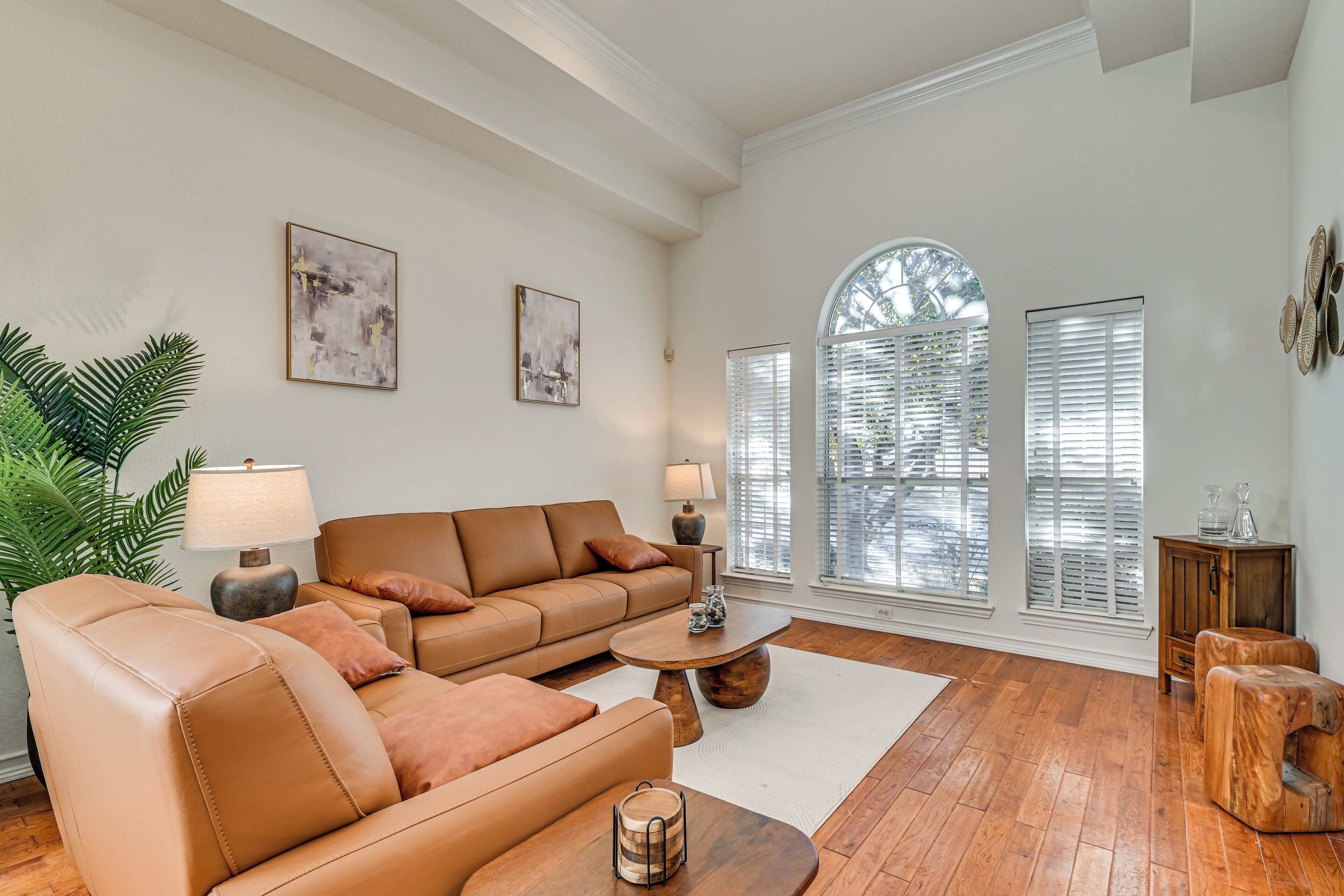 A spacious living room with a large sofa, a coffee table, and a potted plant.