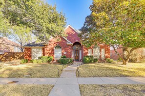 A brick house with a front entrance, a small front yard, and a pathway leading to the door. - Elegant Home w/ Private Patio, 2 Mi to UTD Campus! (Dallas)