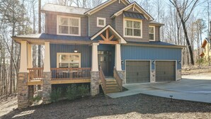 A two-story house with a stone foundation, a front porch, and a garage. - Lake Lure Getaway w/ Hot Tub & Fire Pit! (Lake Lure)