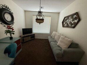 A living room with a sofa, TV, and decorative items. - South Mountain Reserve (Phoenix)