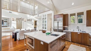 A modern kitchen with a central island, wooden cabinets, and a large window providing natural light. - Private Beach Access | Bikes | Patio (Watersound)