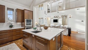 A spacious kitchen with a large island, wooden cabinets, and a modern design. - Private Beach Access | Bikes | Patio (Watersound)