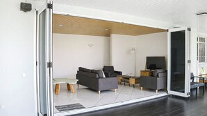 Uma sala de estar moderna com sofá, mesa de centro e televisão.