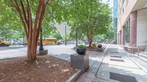 A tree-lined sidewalk with a yellow school bus in the background. - 1BR Condo w/City Views by Peachtree (Atlanta)