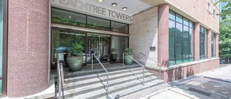 The exterior of a building with a sign reading "PEACHTREE TOWERS".