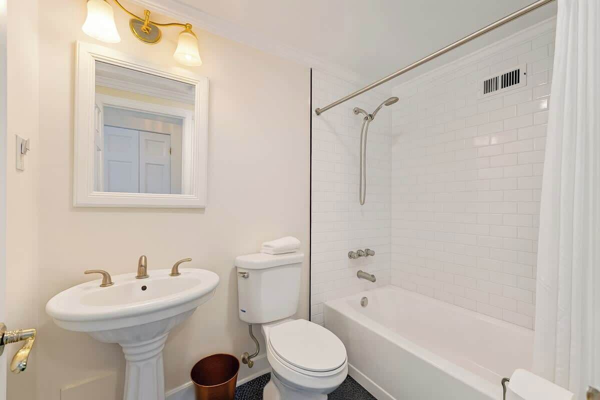 A bathroom with a pedestal sink, toilet, and bathtub.