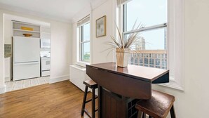 A modern kitchen with white cabinetry, a wooden countertop, and a large window with a view of buildings. - Downtown Atlanta Condo  Walk to Everything (Atlanta)