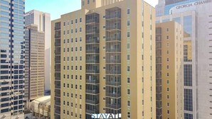Un immeuble à plusieurs étages doté d’une architecture moderne, avec des balcons à chaque niveau.