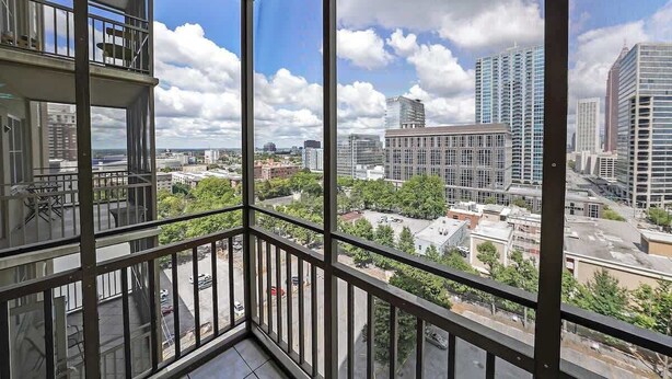 Un appartement situé dans un immeuble de grande hauteur, doté de grandes fenêtres offrant une vue sur le paysage urbain.