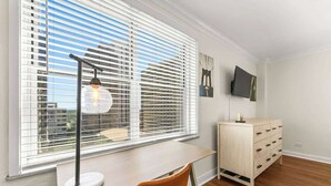 Una habitación con escritorio, silla y cómoda.