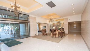 A spacious lobby with a chandelier, seating area, and a glass entrance. - Short walk to Centennial Park and Mercedes Benz (Atlanta)