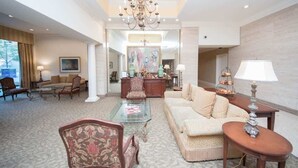 A spacious living room with a chandelier, a sofa, a coffee table, and a dining area in the background. - Short walk to Centennial Park and Mercedes Benz (Atlanta)
