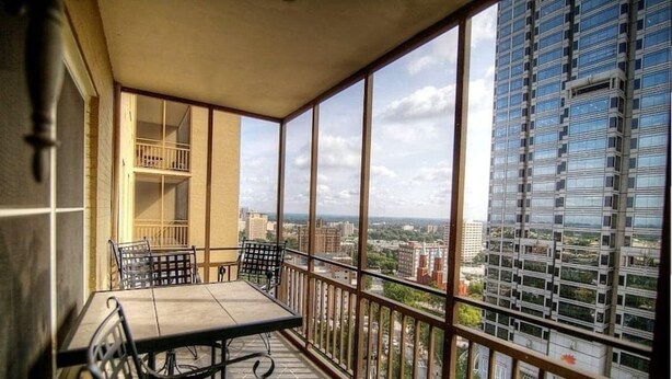 A balcony with a table and chairs, offering a city view. - Cozy High-Rise Condo Near AmericasMart (Atlanta)