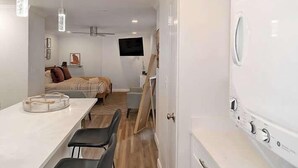Eine kompakte Küche mit Essbereich, einem Wand-Fernseher und einem Deckenventilator.