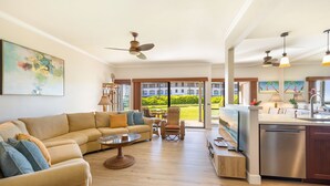 A spacious living area with a beige sofa, a coffee table, and a dining area with a kitchen counter. - VERY SPECIAL  Renovated 1 Bdrm Condo - A/C - Oceanview, Athletic Club Access (Koloa)