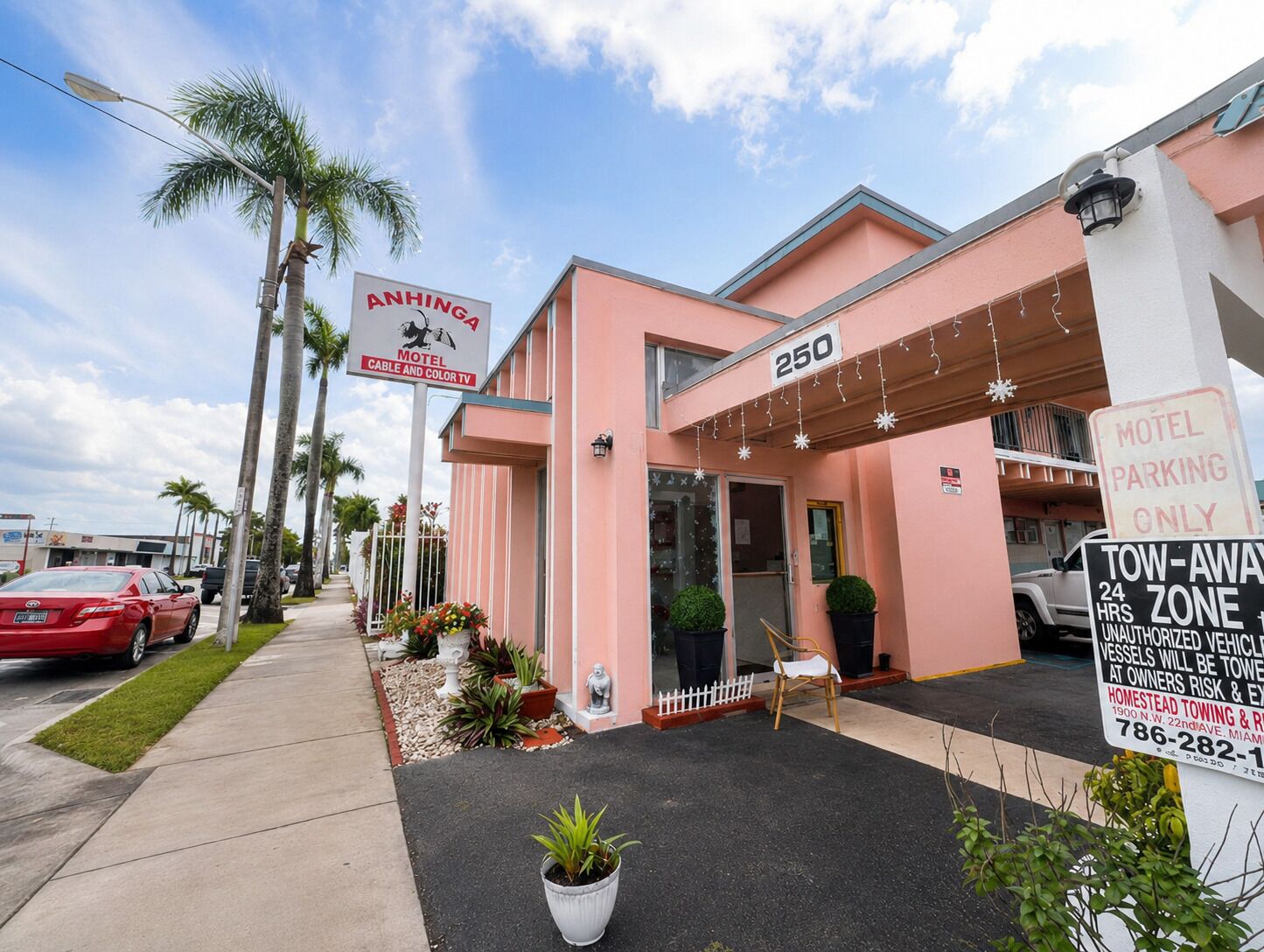 A pink motel with a sign indicating it offers cable and color TV.