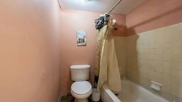 Ein Badezimmer mit Toilette, einer Badewanne und einer Duschvorhang.