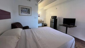 A hotel room with a bed, a television, a microwave, and a small table. - Anhinga Motel Homestead Fl (Homestead)