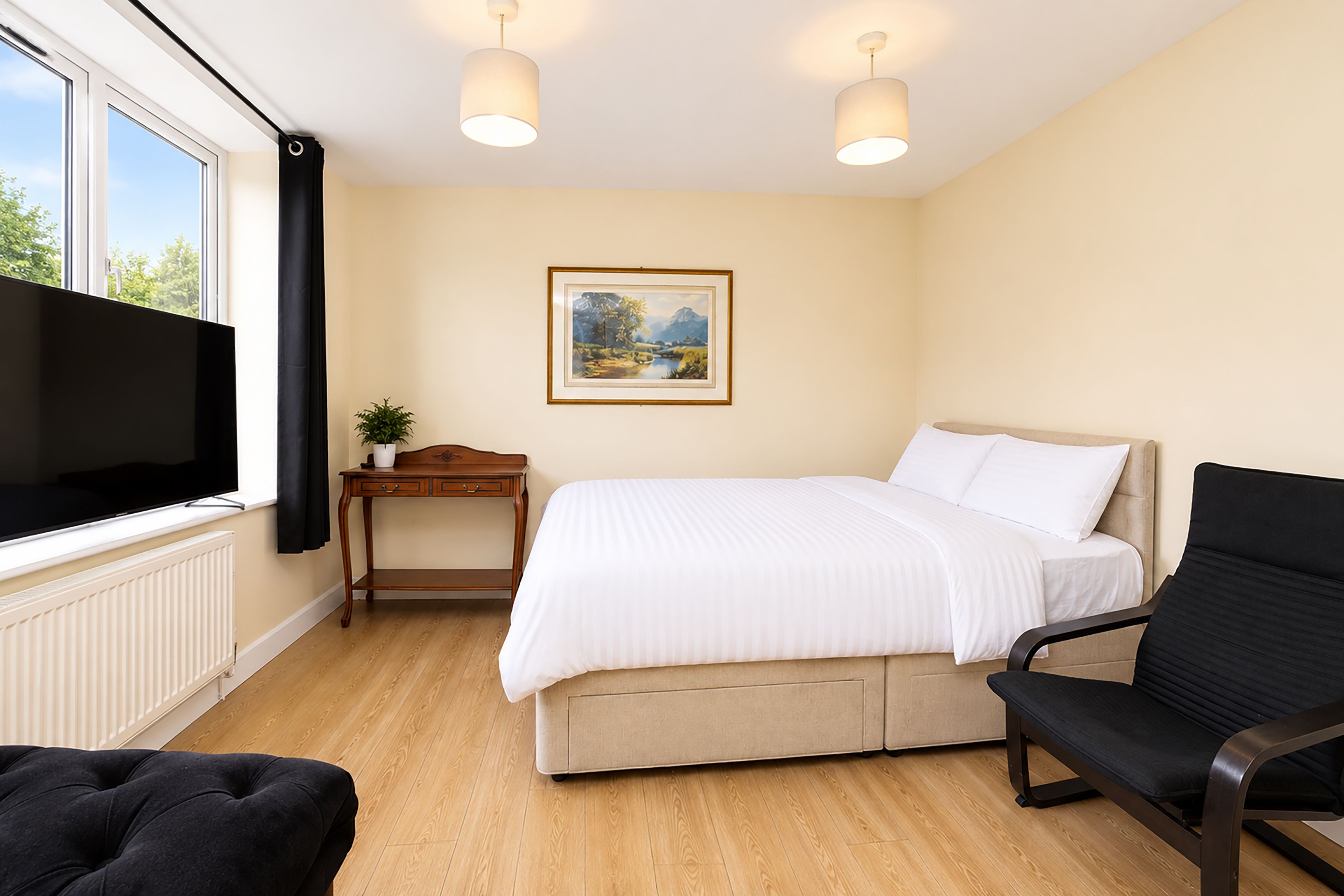 Una habitación de hotel con cama, escritorio, silla, televisor y ventana.
