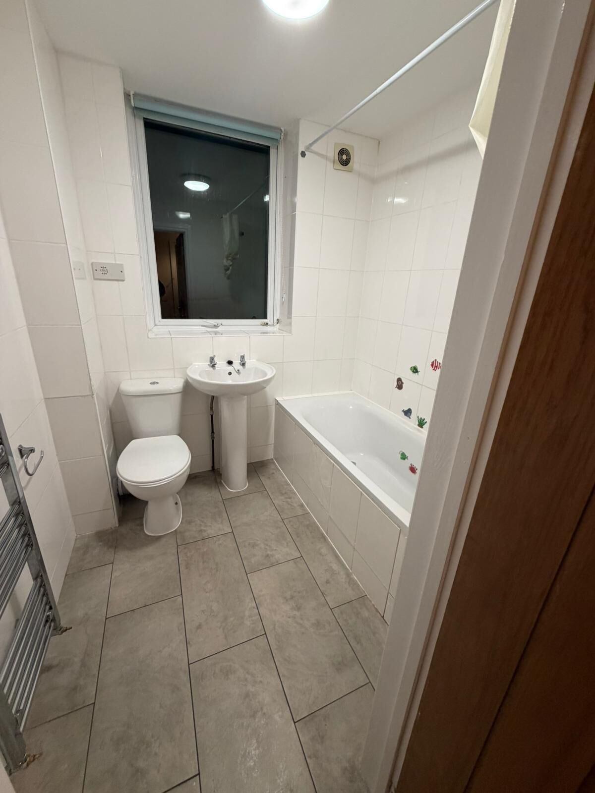 A small, clean bathroom with a toilet, sink, and bathtub.