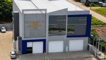 A modern building with a large sign for 'Sun Route Hotel' and a parking area with a few cars.