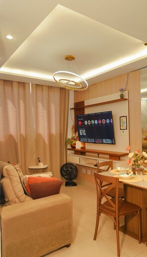 A modern living room with a flat-screen TV, a dining area, and a sofa. - 1503 Apto 2 Qtos completo João Pessoa (Cabedelo)