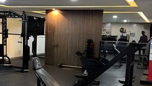 Uma academia com equipamentos de ginástica, uma parede de madeira e um espaço de estar.