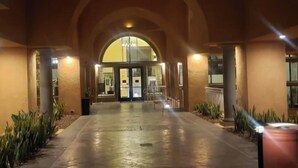 Un arc d'entrada que condueix a un edifici amb una porta de vidre i una recepció.