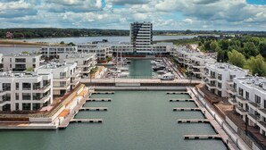 Una marina con edificios modernos, muelles y cielo despejado.