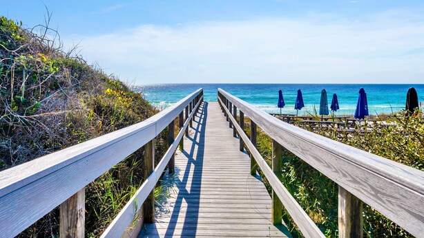 A wooden boardwalk leading to beach umbrellas. - Destin/Miramar Beach Escape, Family-Friendly + Private Beach Access (Destin)