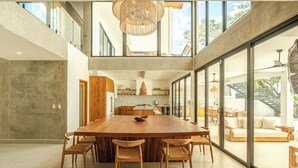 A spacious kitchen with a large island, wooden chairs, and a dining area with a sofa.
