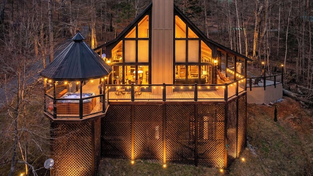 A cabin with a large deck, a covered outdoor seating area, and a chimney. - Smoky Mountain Views • Hot Tub • Fireplace • Cozy Cabin (Sevierville)