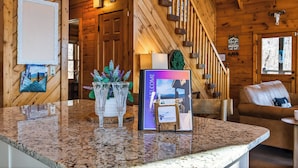 A wooden interior with a reception desk, framed welcome sign, and a staircase. - Smoky Mountain Views • Hot Tub • Fireplace • Cozy Cabin (Sevierville)