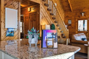 A wooden interior with a reception desk, framed welcome sign, and a staircase. - Smoky Mountain Views • Hot Tub • Fireplace • Cozy Cabin (Sevierville)