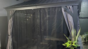 Un patio coperto con un telo nero e una pianta in vaso.