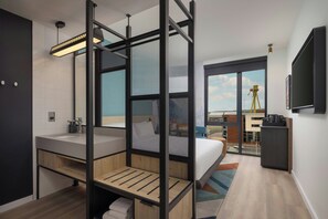 A modern hotel room with a large bed, a separate bathroom, a balcony with a view, and a mounted TV. - Aloft by Marriott Belfast Titanic Quarter (Belfast)