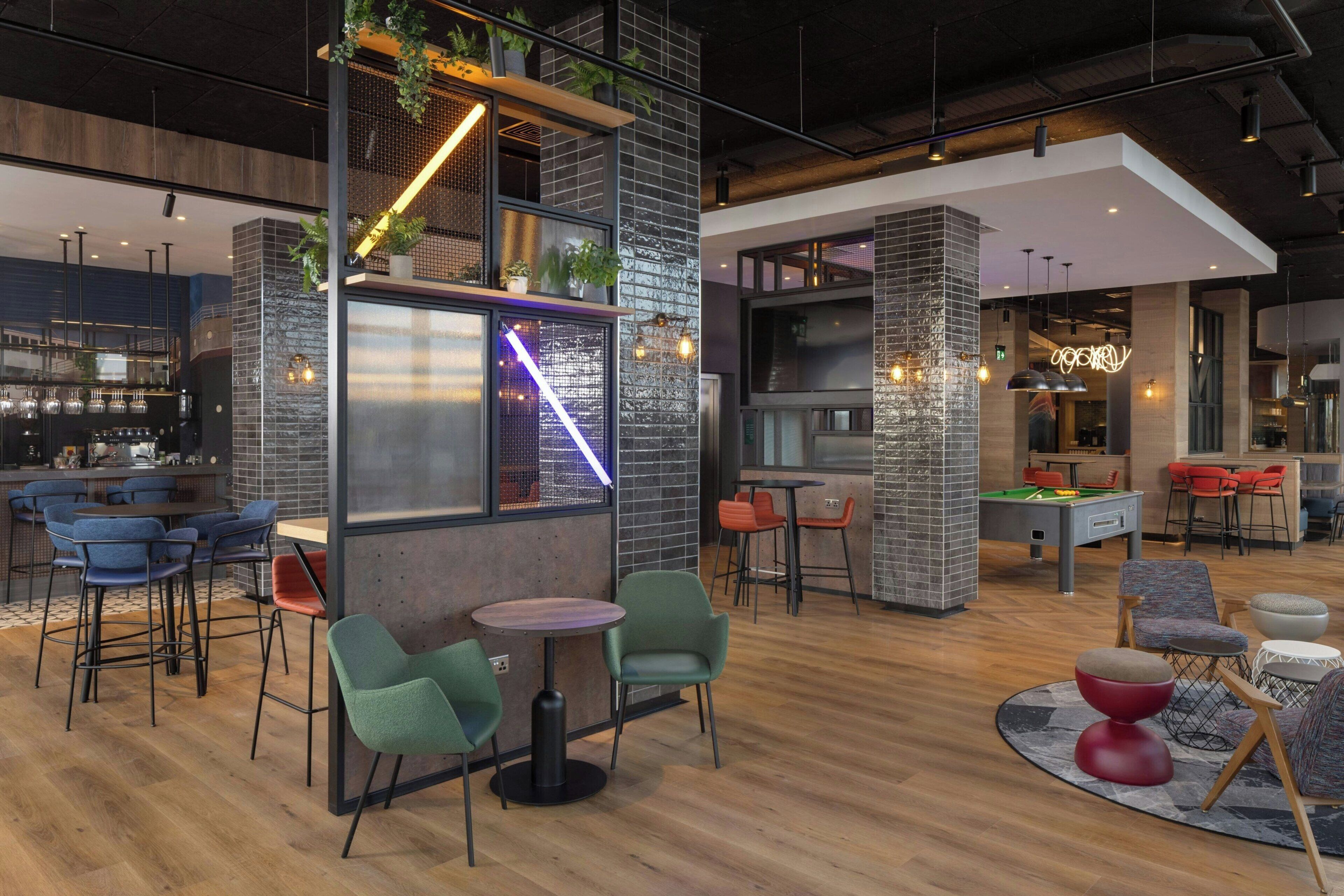 A modern interior with a bar area, seating, and a pool table.
