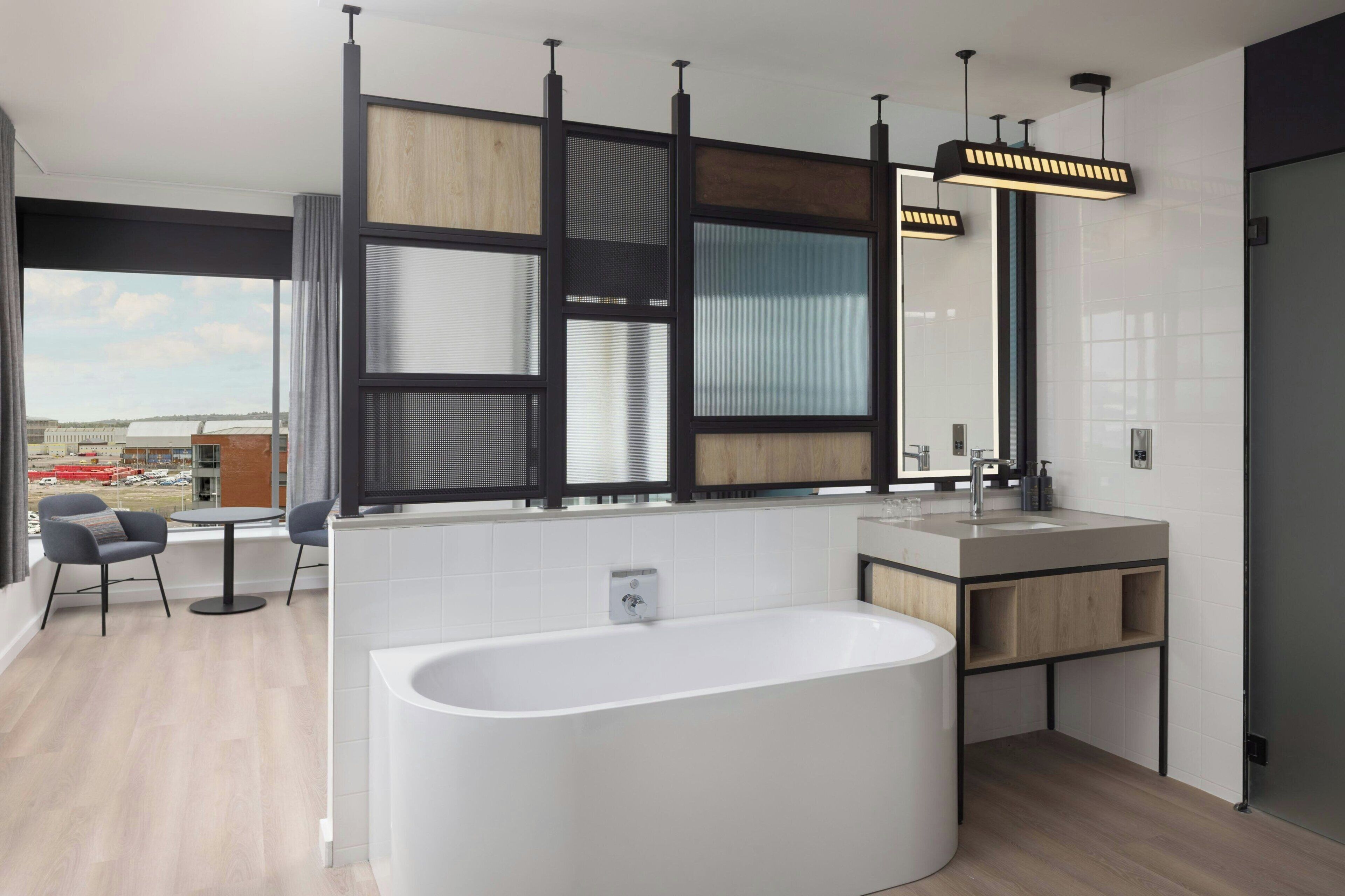 Una cocina moderna con una isla grande, una bañera independiente y un comedor con sillas.