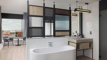 Una cocina moderna con una isla grande, una bañera independiente y un comedor con sillas.
