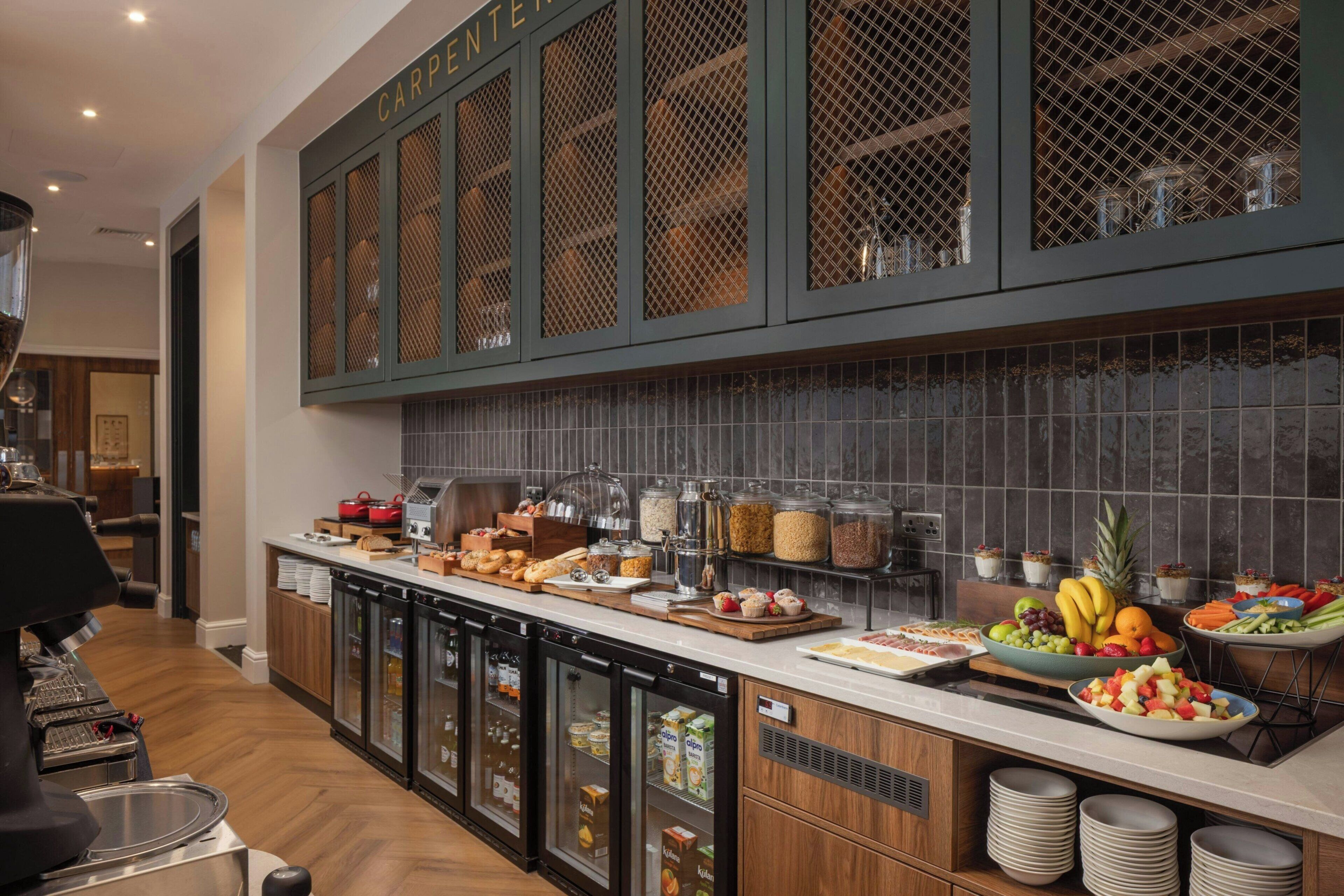 A buffet area with a variety of food items, refrigerated storage, and a coffee machine.