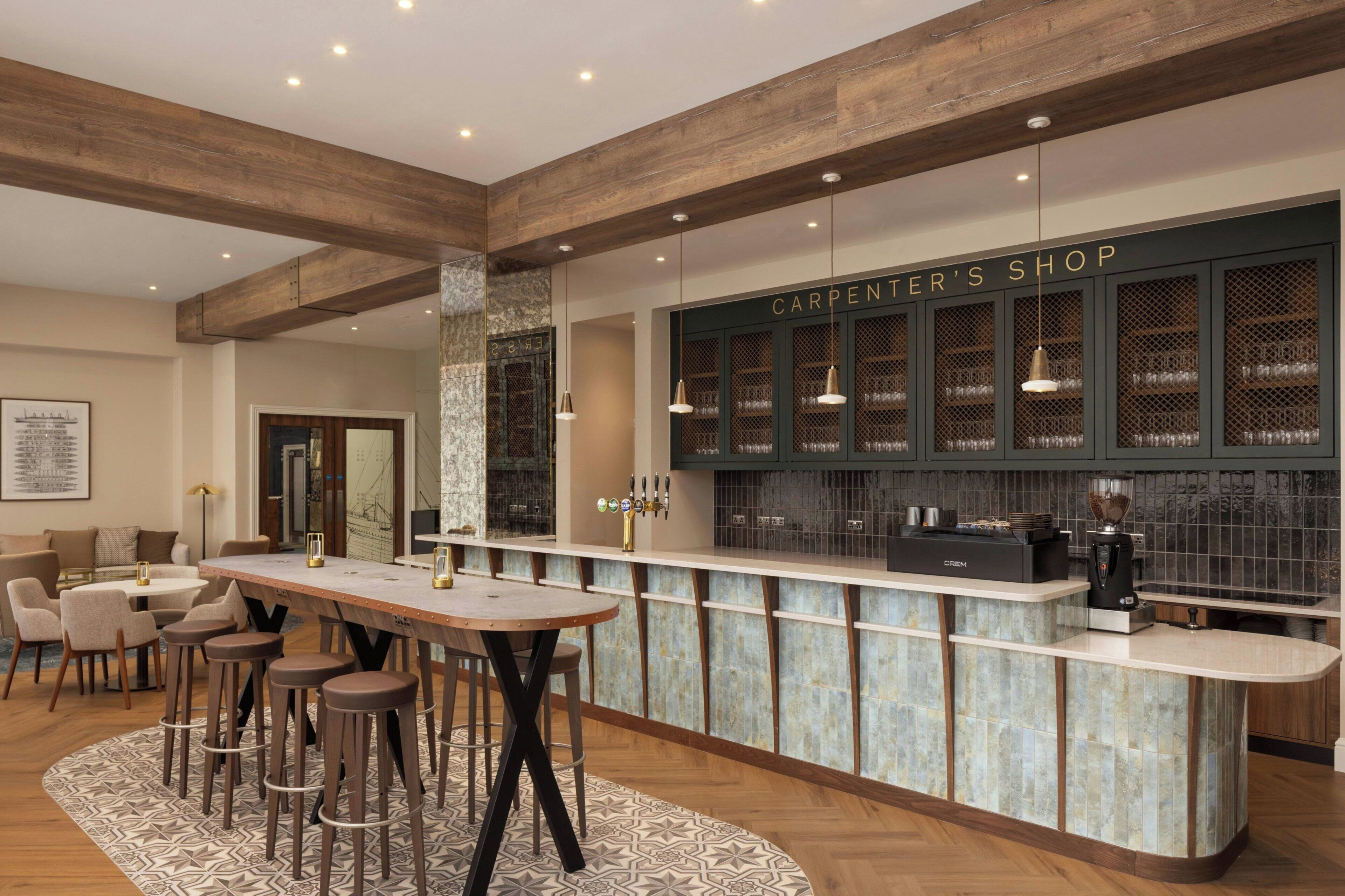 A bar area with stools, a counter, and a sign reading 'CARPENTER'S SHOP'.