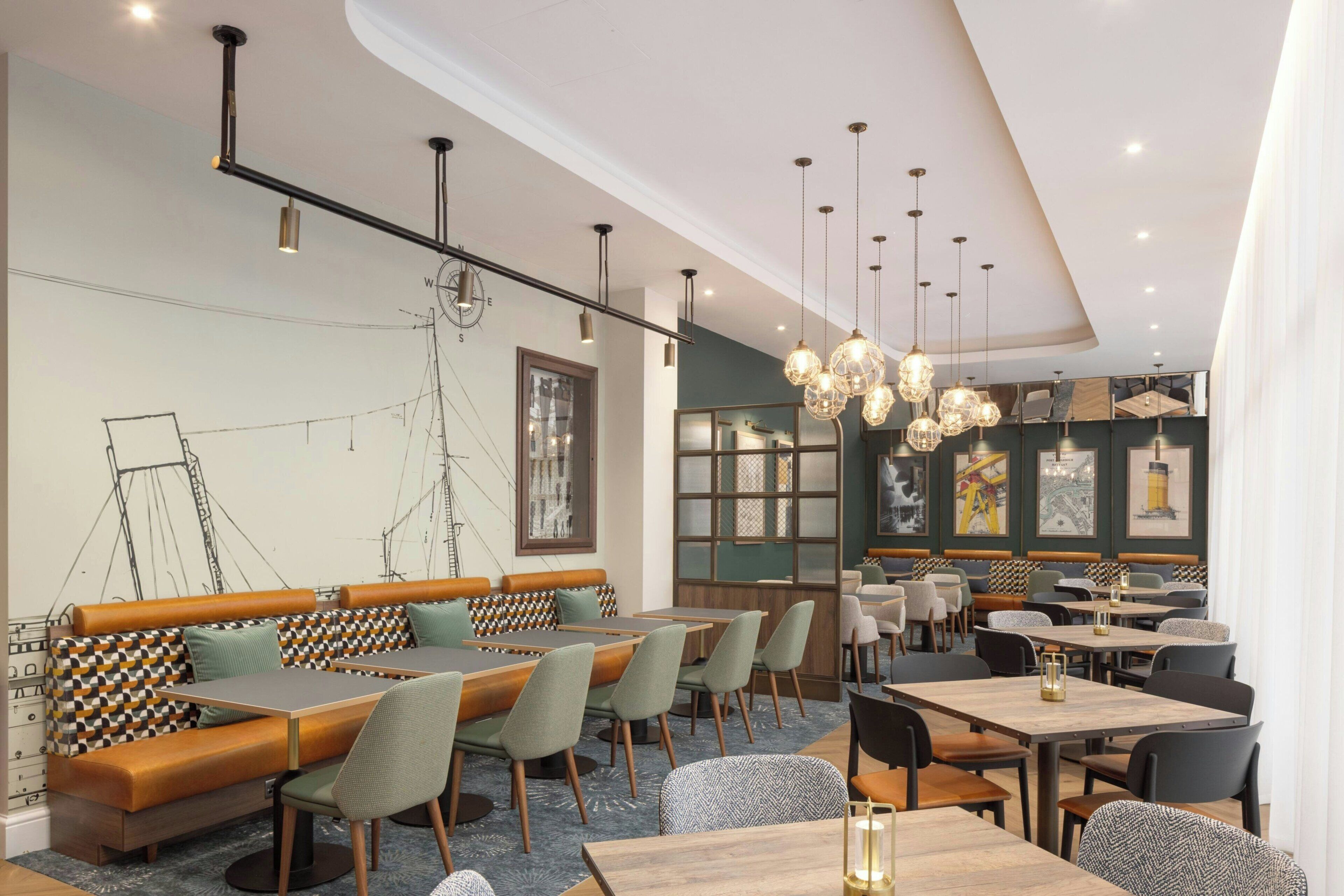 A modern restaurant with wooden tables and benches, pendant lighting, and artwork on the walls.