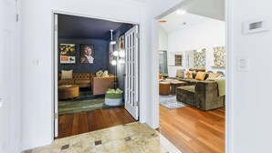 Una sala de estar amplia con una pared de acento azul oscuro, un sofá grande y una mesa de centro.