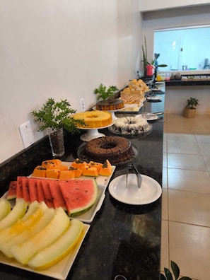 Un bufé con distintos alimentos y una planta en la barra.