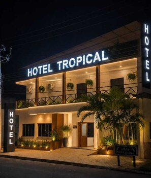 Un hôtel appelé «HOTEL TROPICAL», doté d’un design moderne, avec un balcon agrémenté de plantes et une enseigne indiquant «PAPELHINIA».