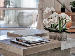 A modern living room with a coffee table, books, and a potted orchid. - Chic 2BR condo in the heart of Orlando Downtown (Orlando)