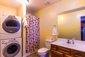 A compact bathroom with a washing machine, toilet, and sink. - House # 21 Sure Catch Not Pet-friendly (Leesburg)