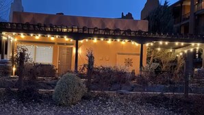 A building with a covered entrance, string lights, and a door. - Osoyoos Lakeview Villa Canada's Warmest Paradise (Osoyoos)
