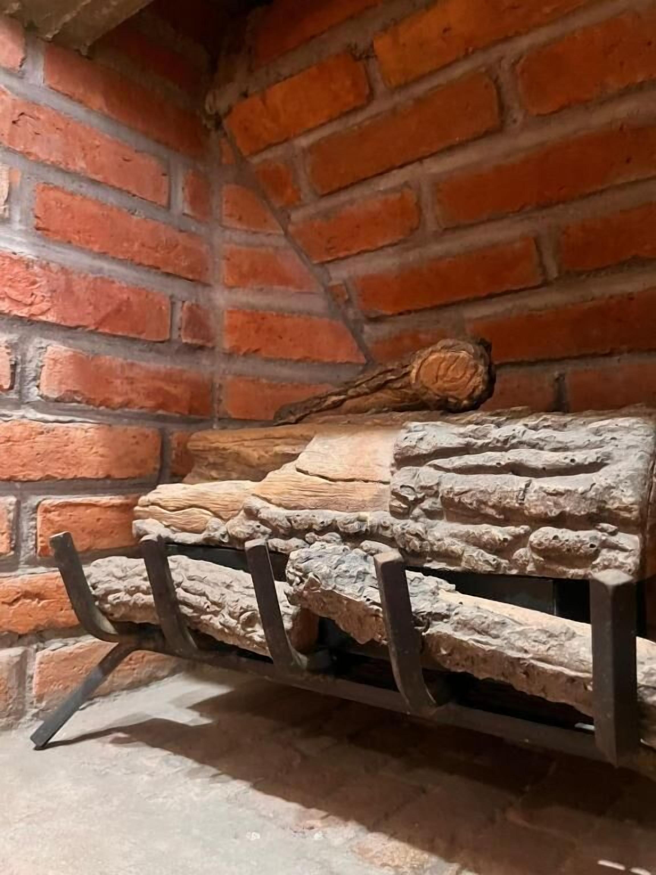Una pared de piedra con un rústico conjunto de troncos de madera.
