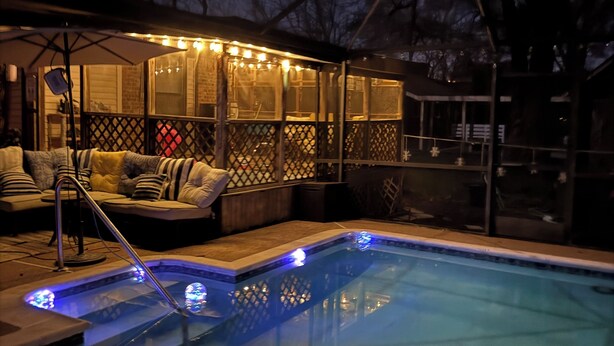 A swimming pool with a hot tub and deck seating, surrounded by a covered patio area with string lights. - Tournament Ready Stay •Close to Parks •3 bedroom/2 bath •Pool/HotTub (College Station)